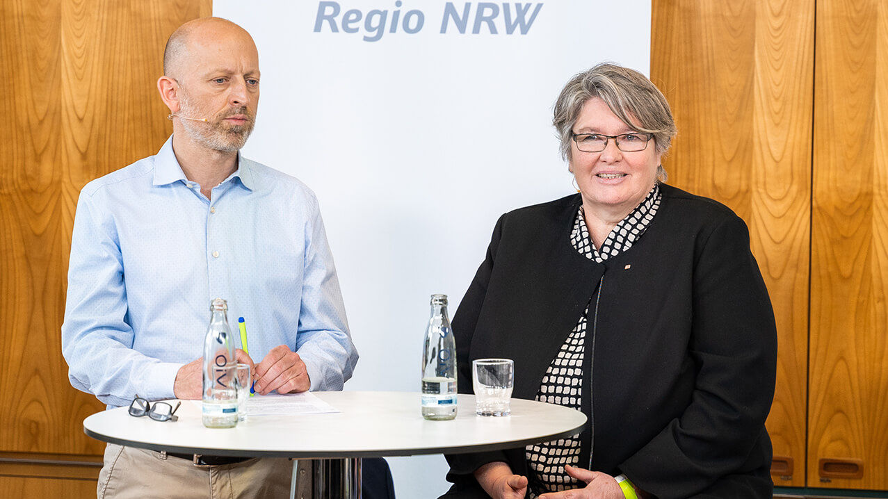 Frederik Ley (Vorsitzender der Regionalleitung DB Regio NRW) und Susanne Eichenberg (HR-Managerin bei DB Regio AG) stehen an einem Stehtisch.