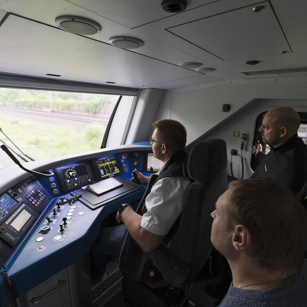 Vier Personen sitzen im Führerstand eines RE5, in dem eine Schnupperfahrt durchgeführt wird.