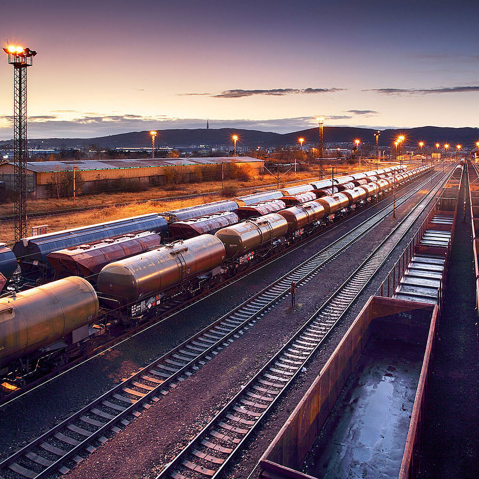 Panoramaansicht von mehreren Güterzügen bei untergehender Sonne.