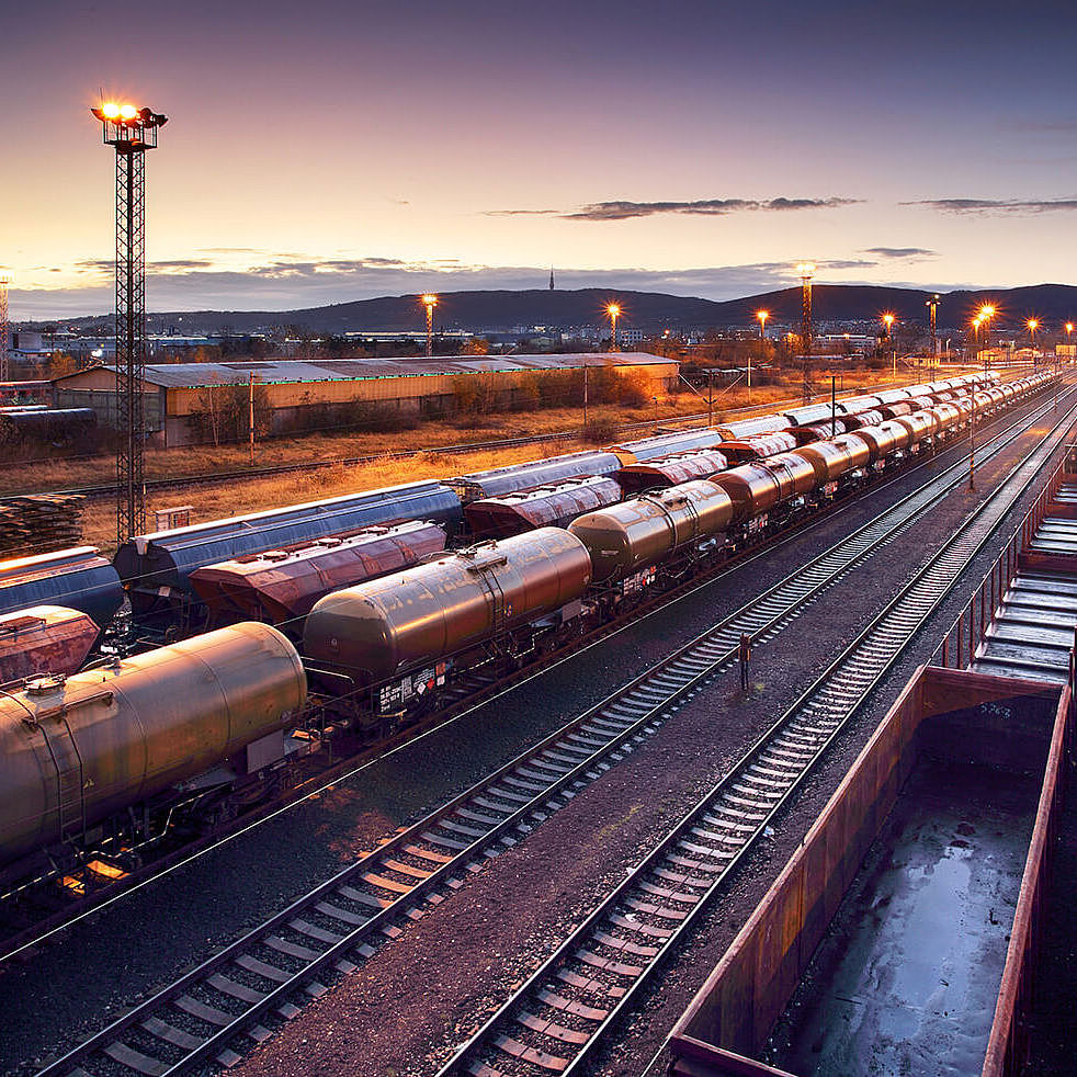 Panoramaansicht von mehreren Güterzügen bei untergehender Sonne.