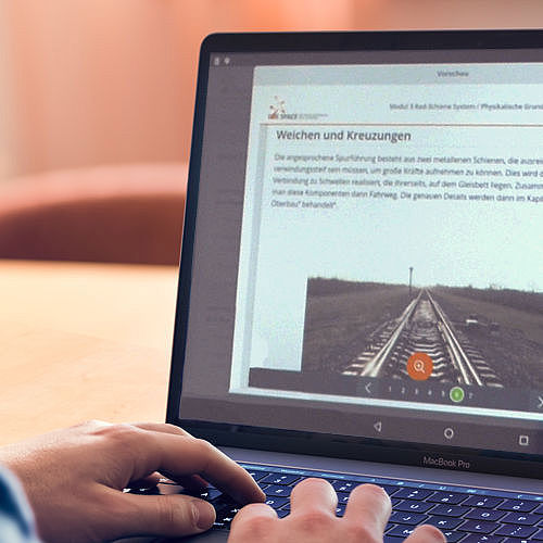 Ein Mann Tippt auf einem Laptop, die Online-Seite von Lokspace ist auf dem Bildschirm zu sehen. 