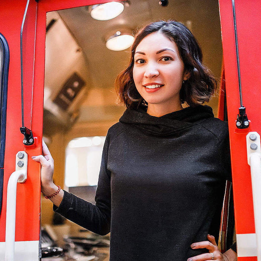 Eine junge Frau schaut aus dem Führerstand eines Regionalzuges