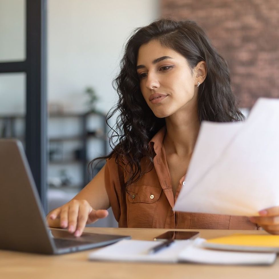 Das Bild zeigt eine junge Frau, die am Laptop sitzt und lernt