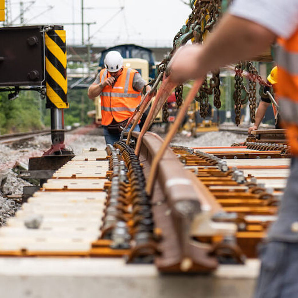 Bauarbeiter verlegen Gleise für den Streckenausbau des RRX.