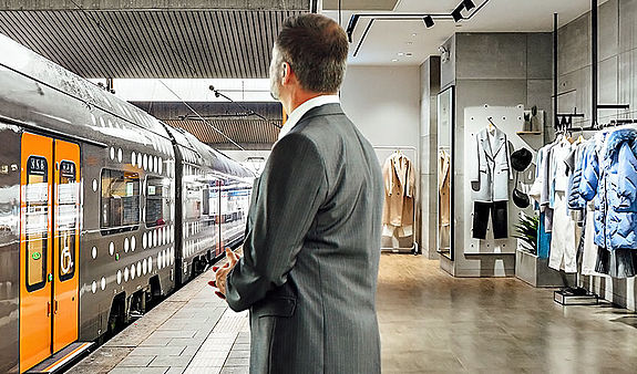 Ein Bildcomposing: Ein Mann steht auf einem Bahnsteig. Vor ihm ist ein RRX-Fahrzeug zu sehen. Hinter ihm ist die Innenansicht eines Kleidungsgeschäfts zu sehen.