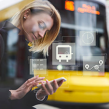 Eine junge Frau steht vor einer Straßenbahn und hat ein Handy in der Hand. Darüber schweben grafisch dargestellt mehrere Symbole in Bezug auf den Nahverkehr.